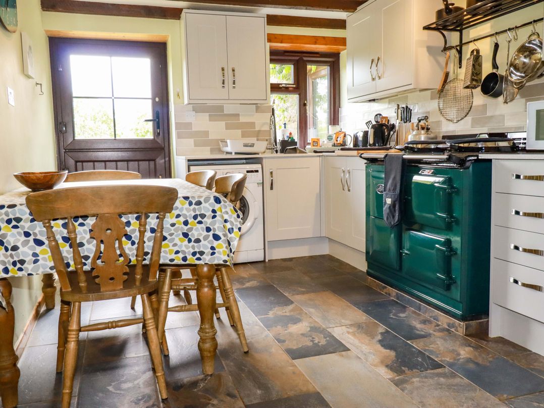 A kitchen with a table and chairs at 4 Mowhay Cottages in Gorran Haven