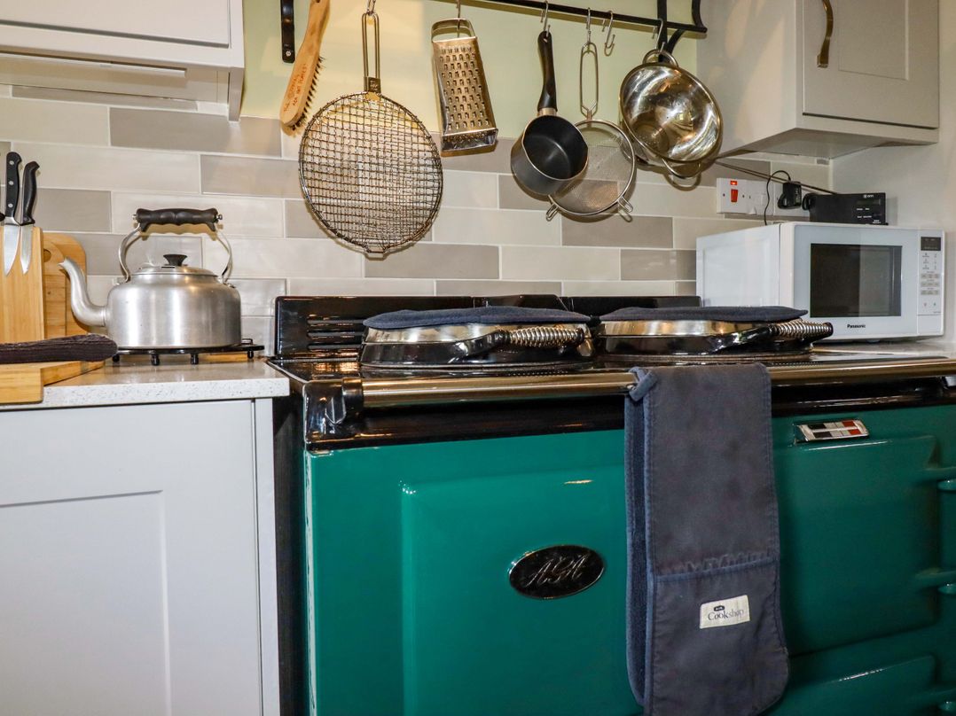 A kitchen with an oven and various utensils at 4 Mowhay Cottages in Gorran Haven