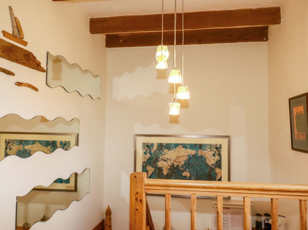 A staircase with wooden railing and world map at 4 Mowhay Cottages Gorran Haven