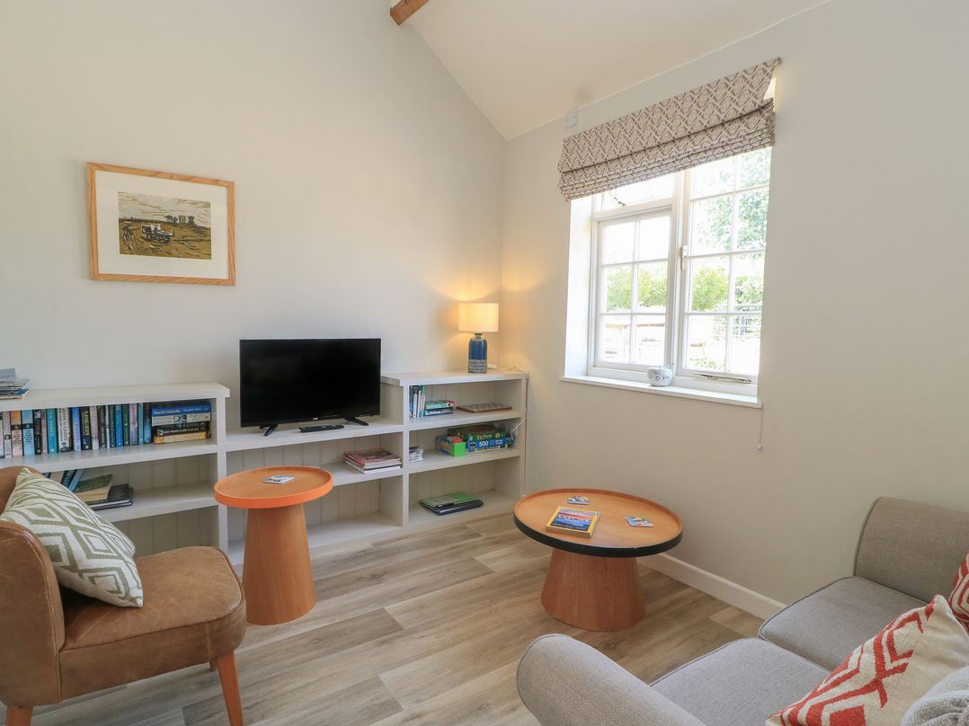 A living room with a sofa and television at The Apple Shed, Motcombe