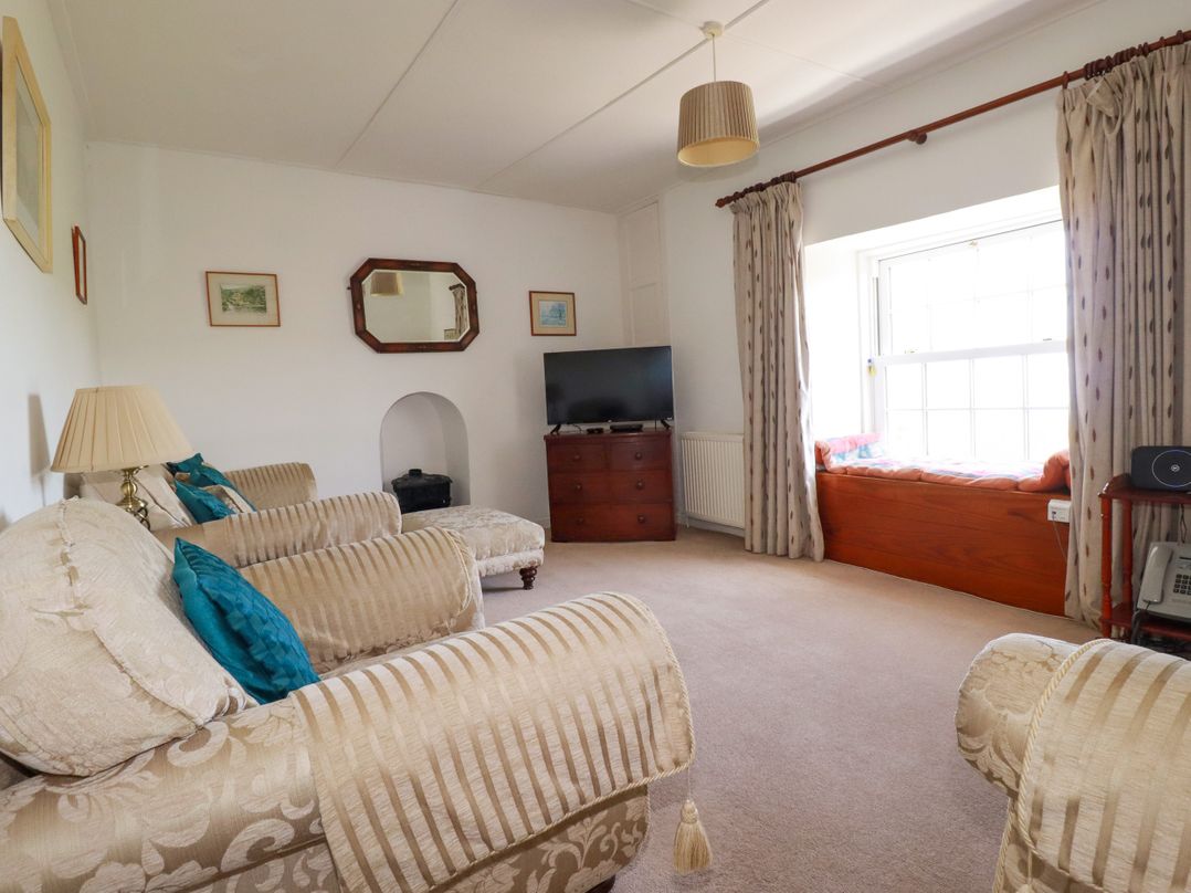 A living room with a sofa and television at Penrose Farm Cottage St Keverne