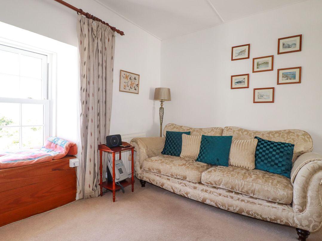 A living room with a sofa and window at Penrose Farm Cottage St Keverne