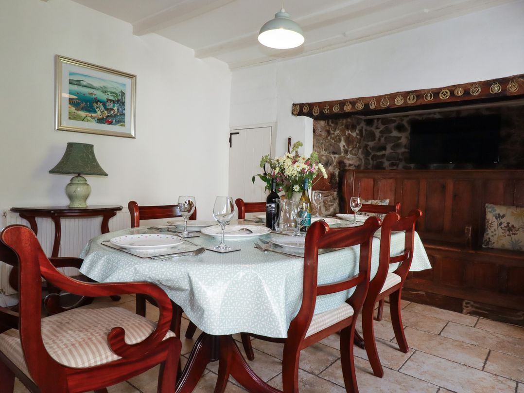 A dining room with a table set for six at Penrose Farm Cottage St Keverne