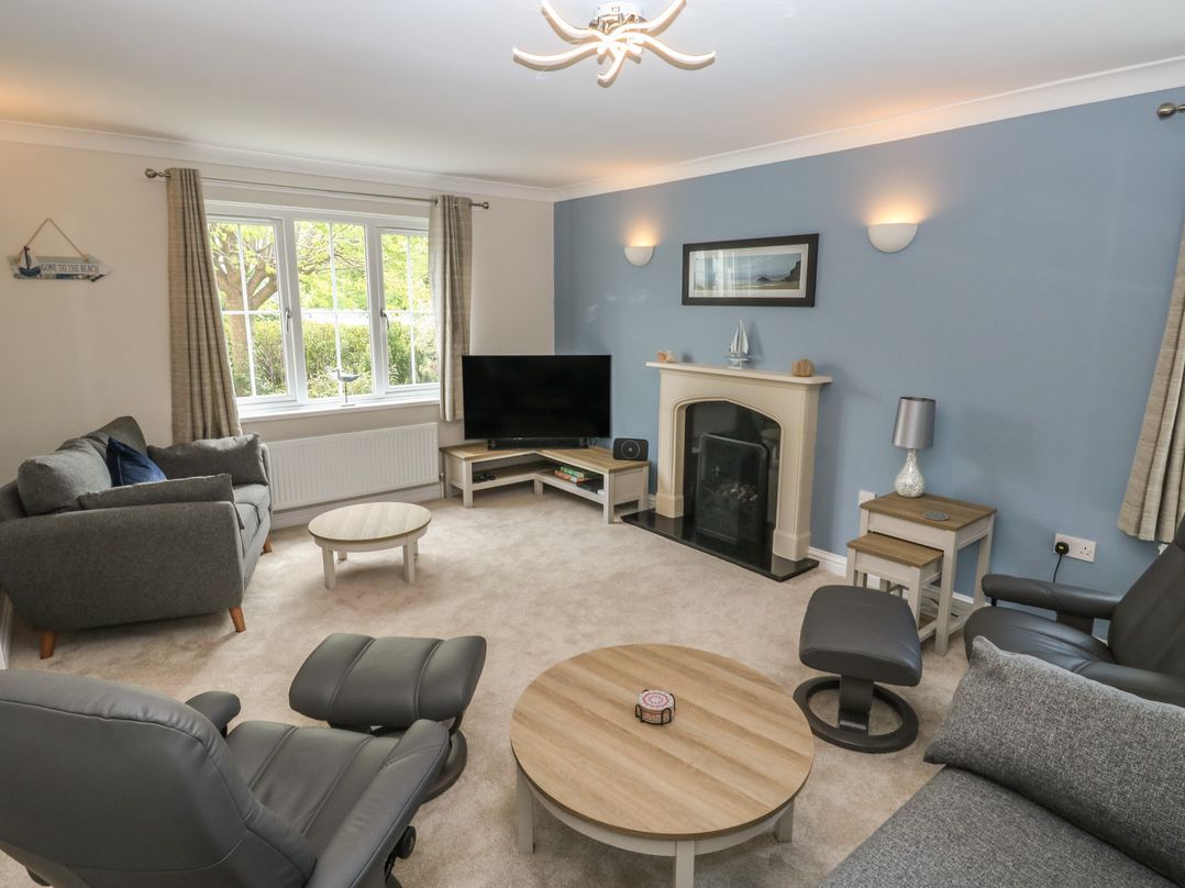 A living room with a television and sofas at Glebe House in Bigbury