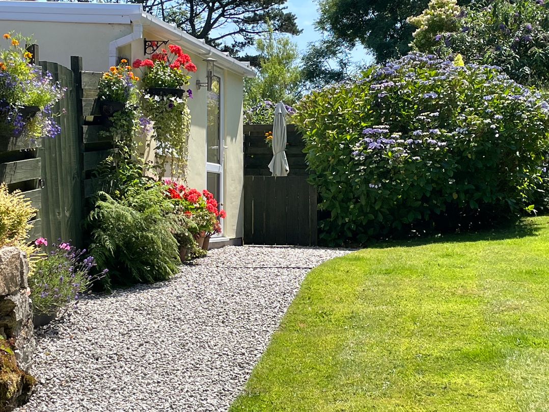 A garden with gravel path and flowers at Garden Cottage St Just