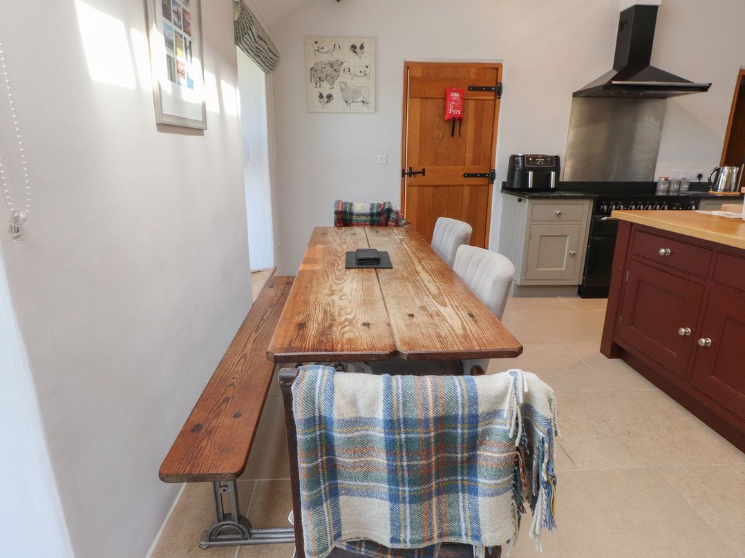 A kitchen with a wooden table and chairs at Wern Olau Cottage Groeslon near Caernarfon