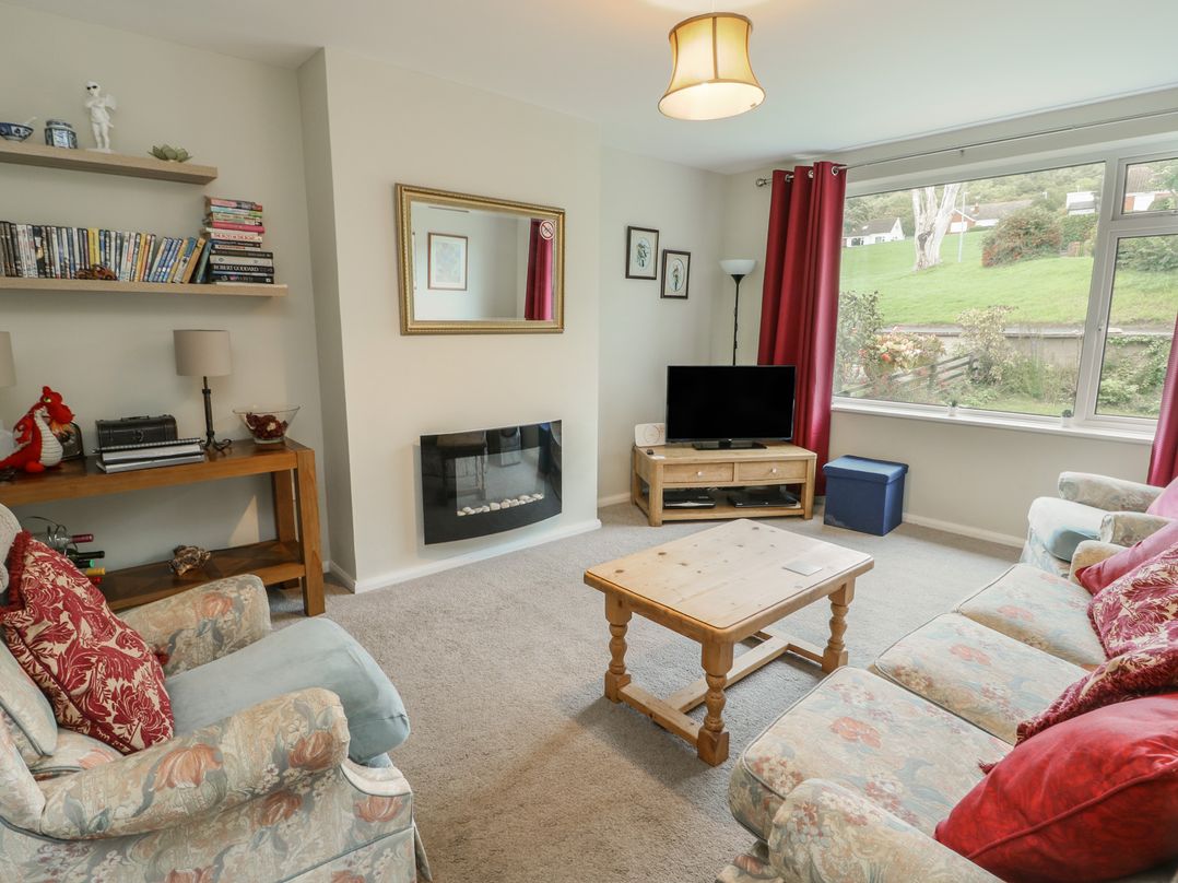 A living room with a television and a coffee table at Awelon in Rhos-On-Sea