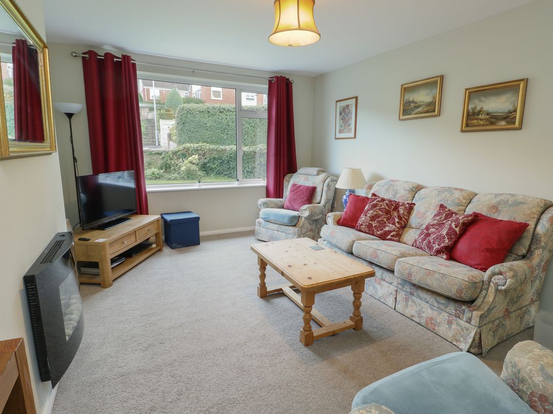 A living room with sofas and a television at Awelon in Rhos-On-Sea