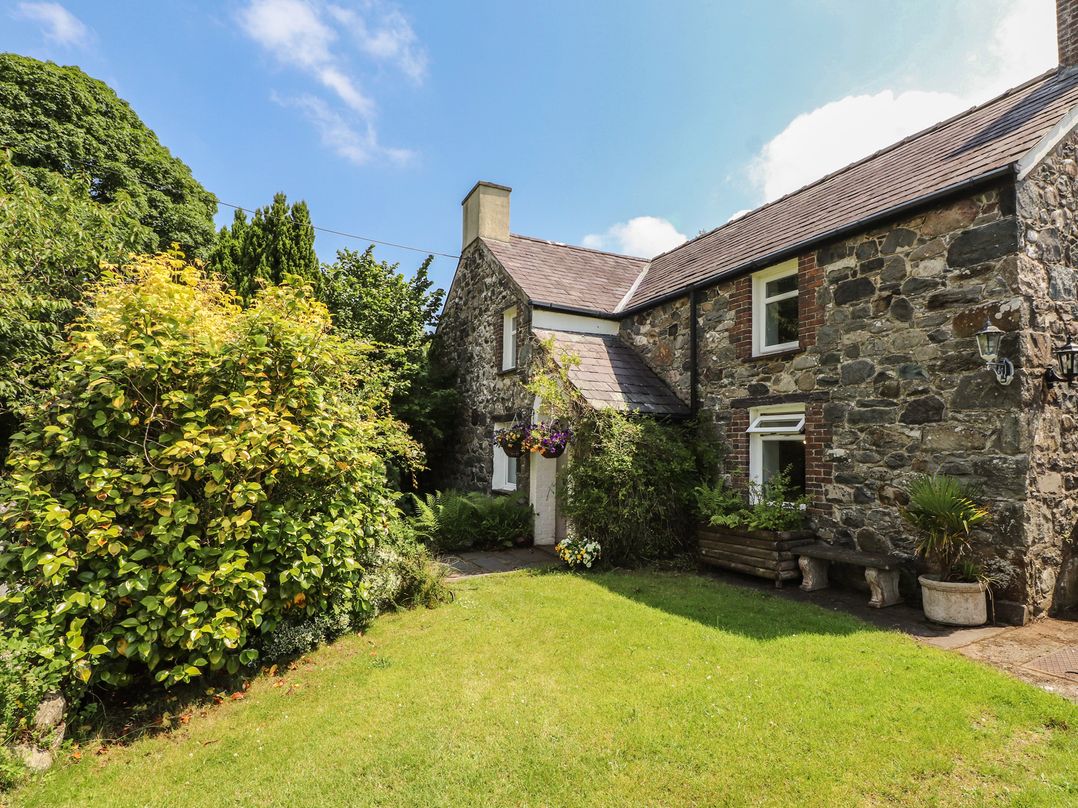 A stone house with a garden at Plas Mawr in Groeslon