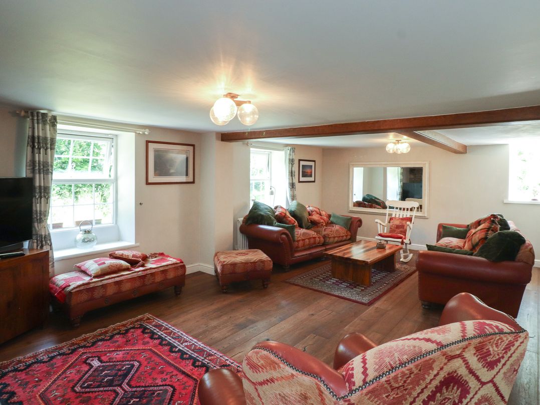 A living room with sofas and a coffee table at Plas Mawr in Groeslon