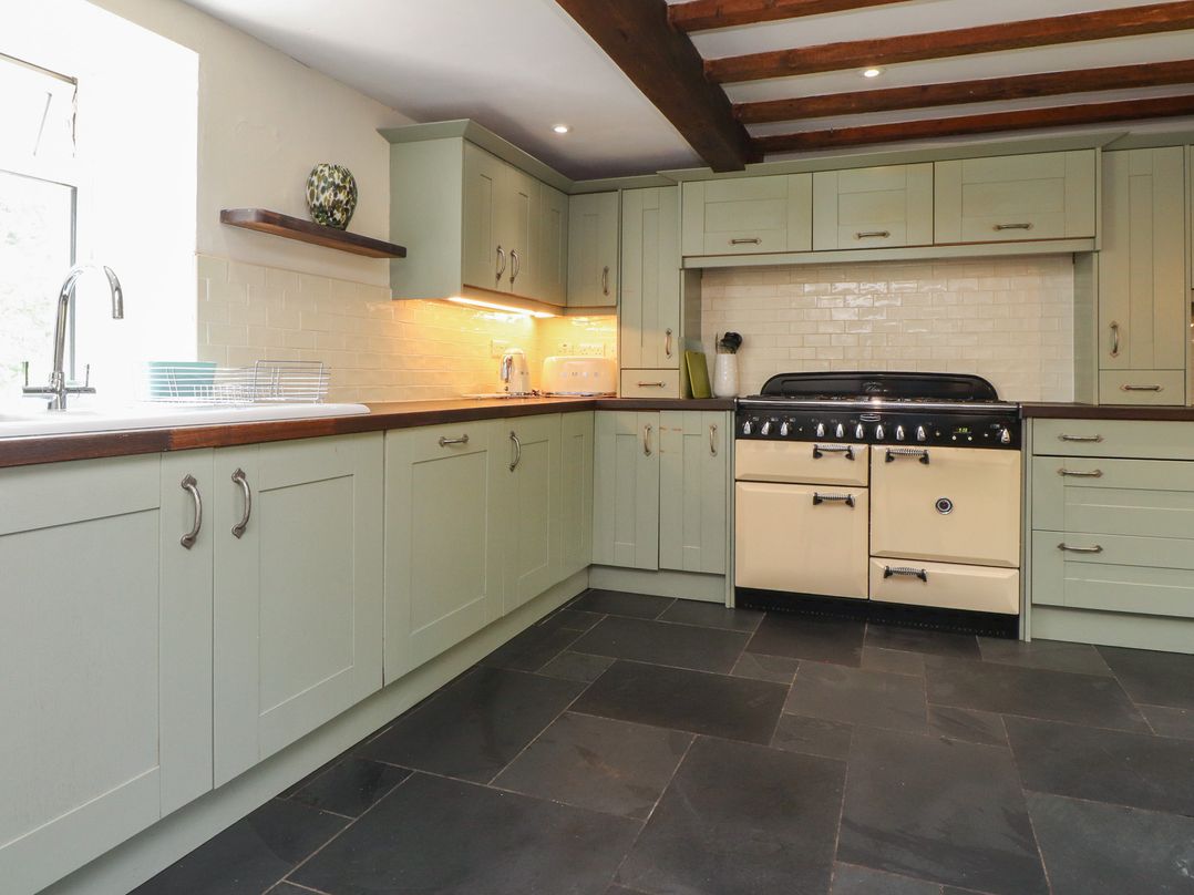 A kitchen with cabinets and stove at Plas Mawr in Groeslon