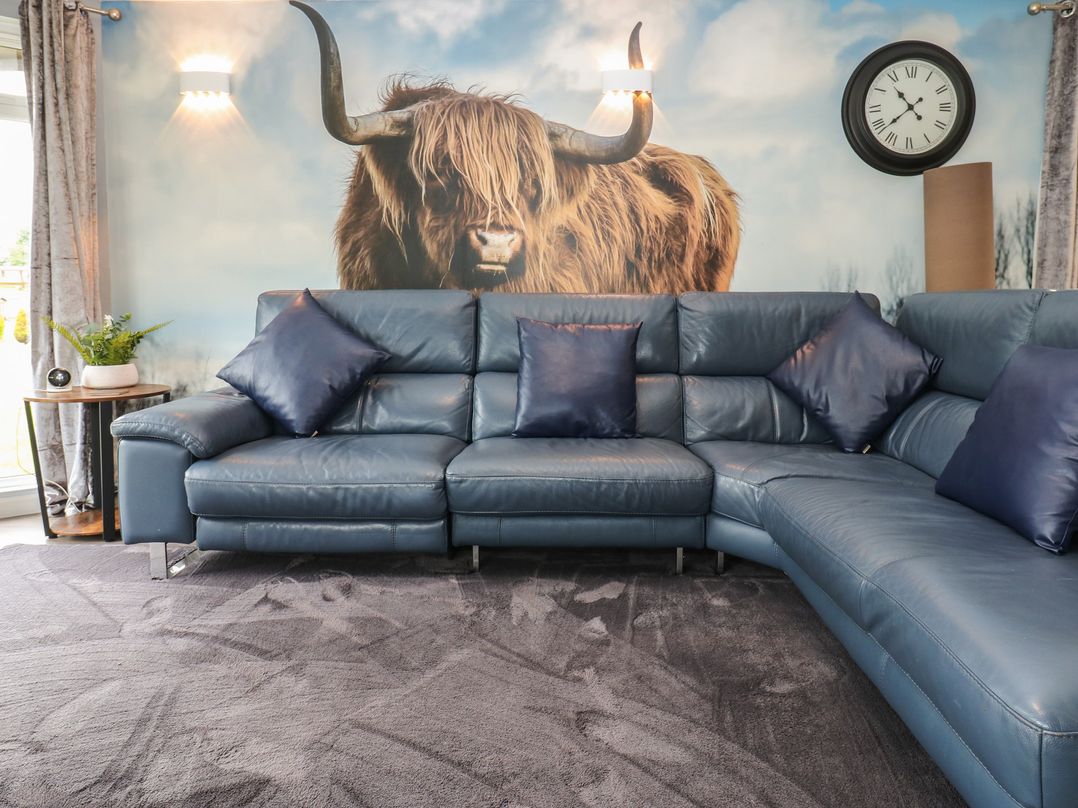 A living room with a blue sofa and wall art at 16 Badgers Retreat Richmond