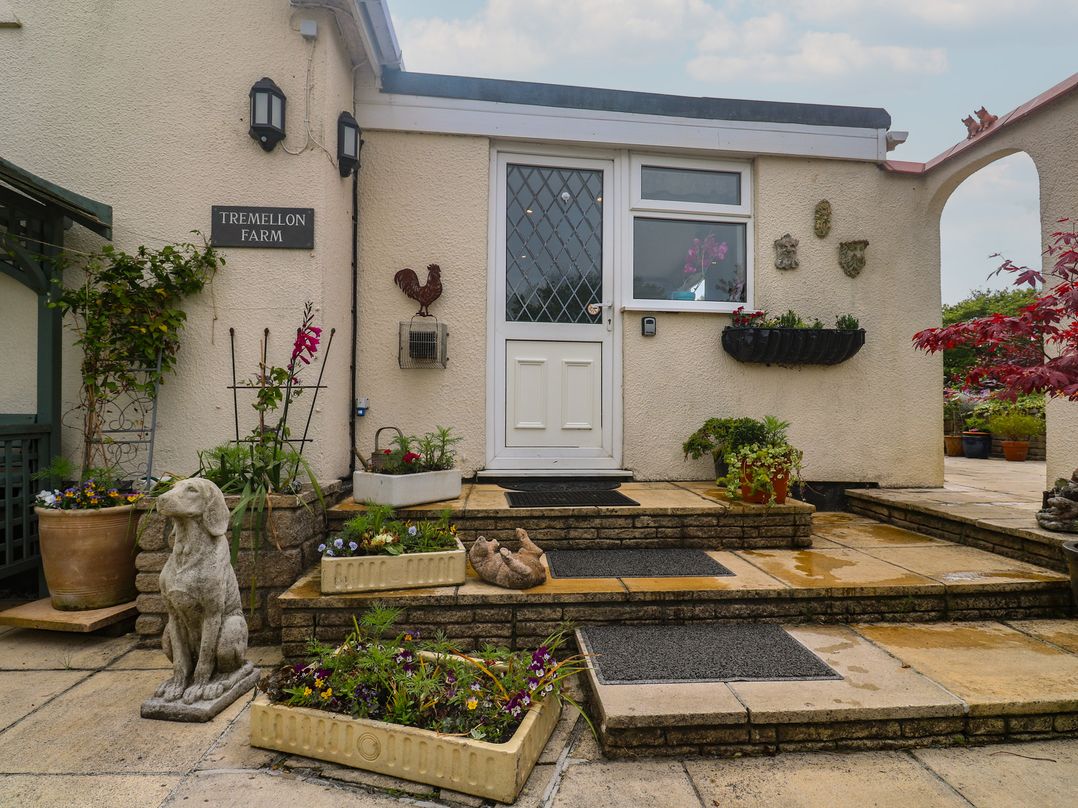 An entrance with flower pots and decorative statues at Tremellon Farm in Goldsithney