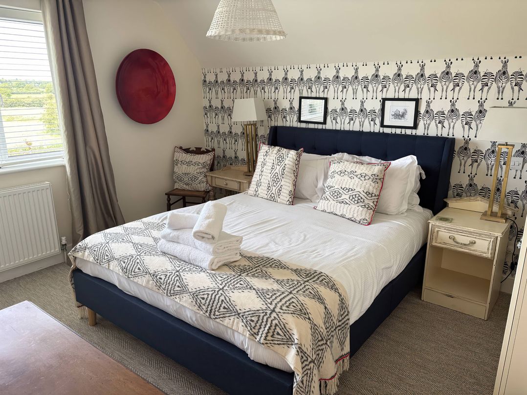 A bedroom with a bed and side tables at Fairview Cottage in Milton-Under-Wychwood