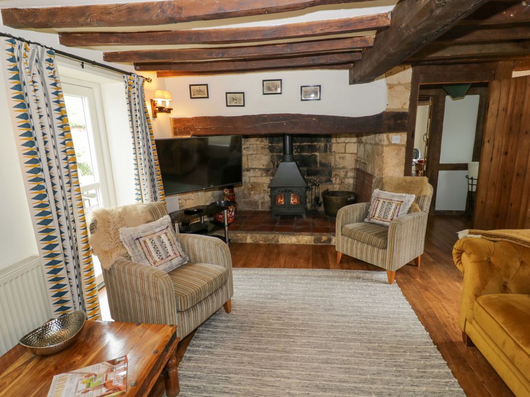 A living room with armchairs and a fireplace at Elmhurst Cottage in Lower Quinton