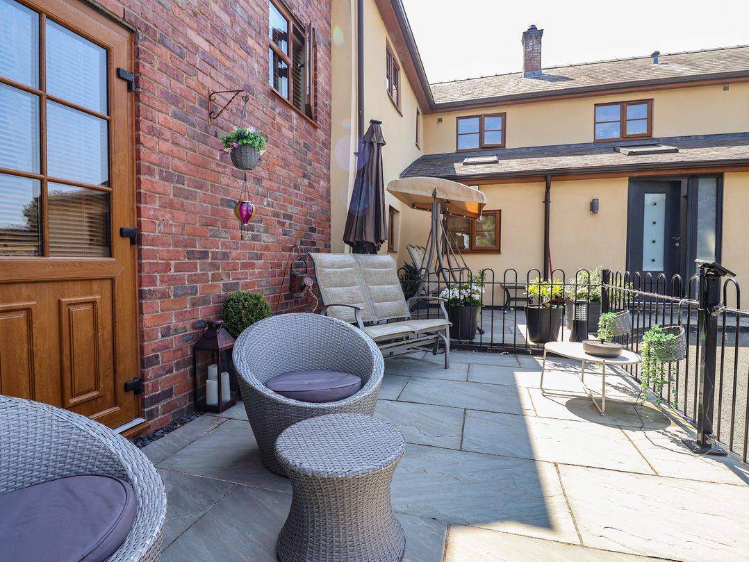 An outdoor area with seating and plants at Ash Farm Cottage in Lixwm near Caerwys
