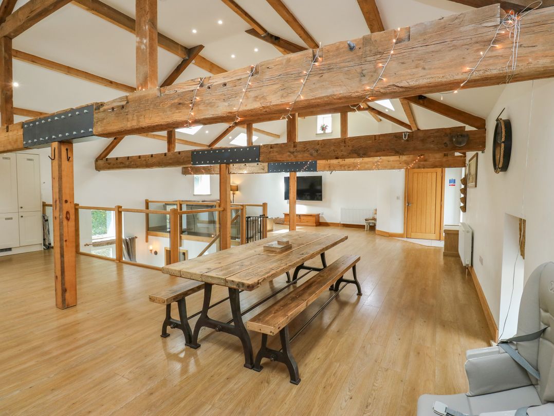 A dining room with a table and chairs at Upper House Barn (Saddleworth) Delph
