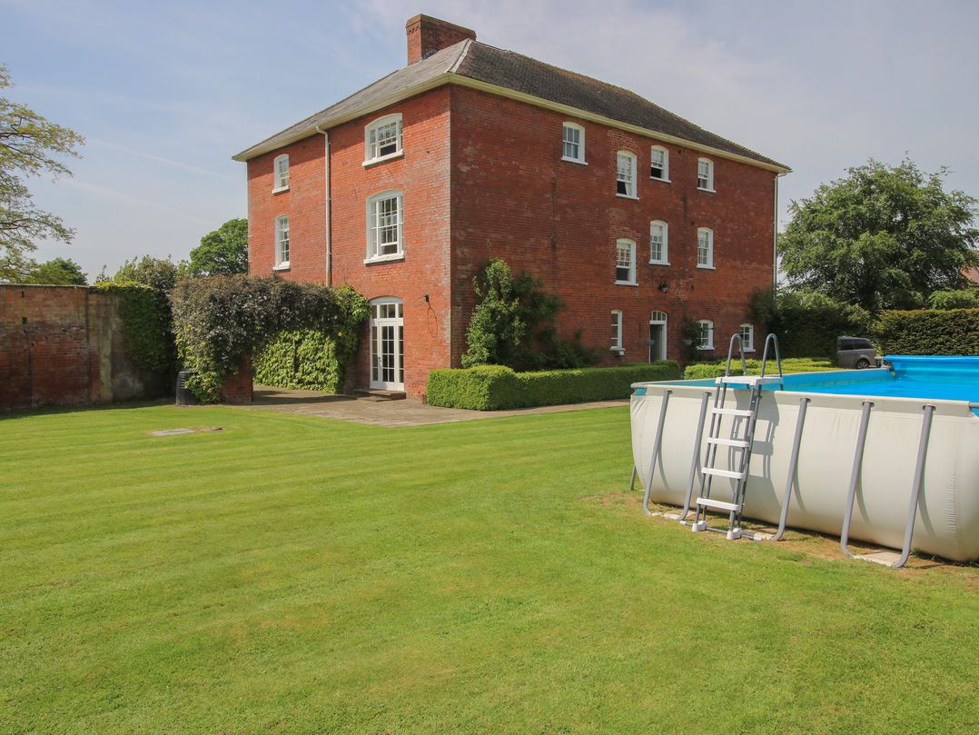 A house with a pool and lawn at Hilltop House in Tenbury Wells