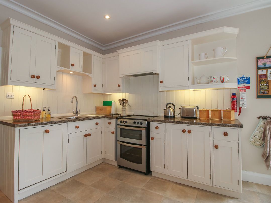 A kitchen with cabinets, sink, oven, and appliances at The Old Nursery in Bourton near Much Wenlock