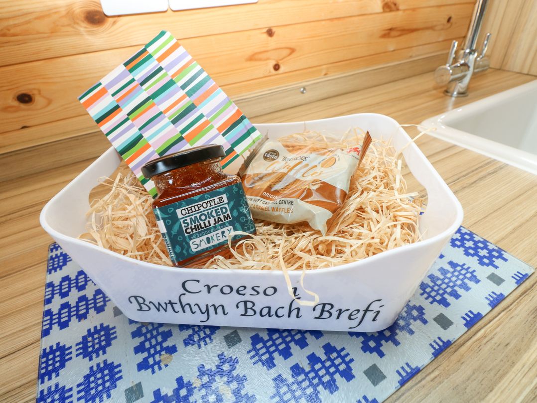 A basket with snacks and a card on a countertop at Bwthyn Bach Brefi Llanddewi-Brefi