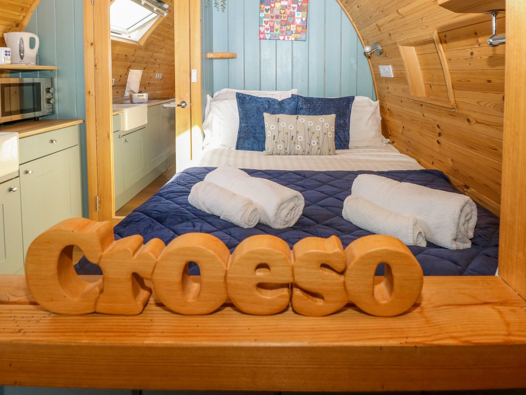 A bedroom with a bed and kitchenette at Bwthyn Bach Brefi in Llanddewi-Brefi