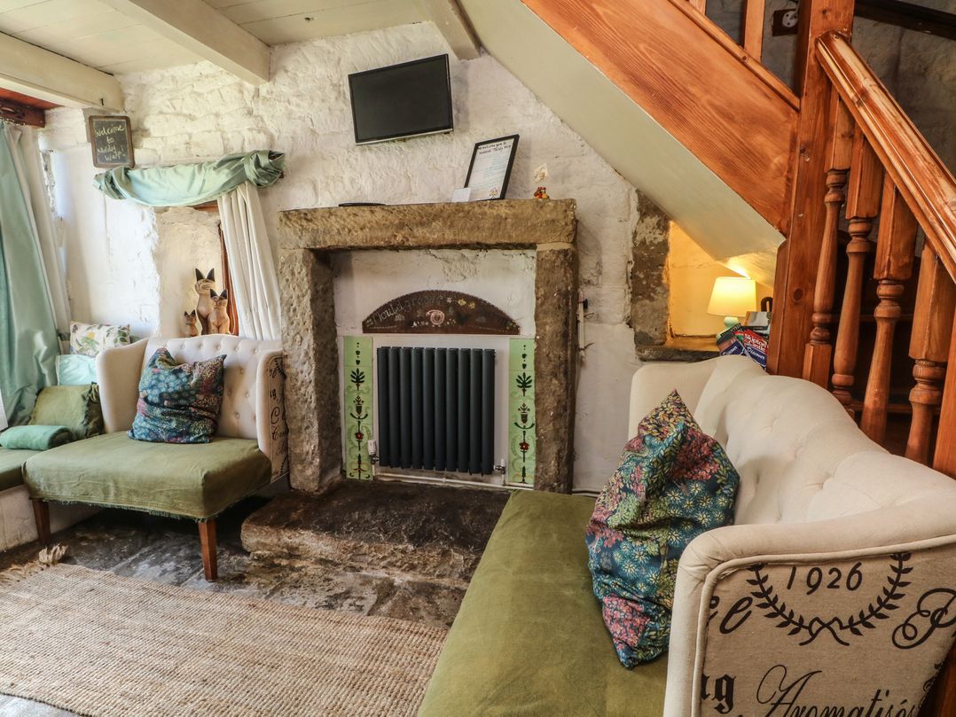 A snug with sofas and a fireplace at Moldy Warp Barn in Haworth