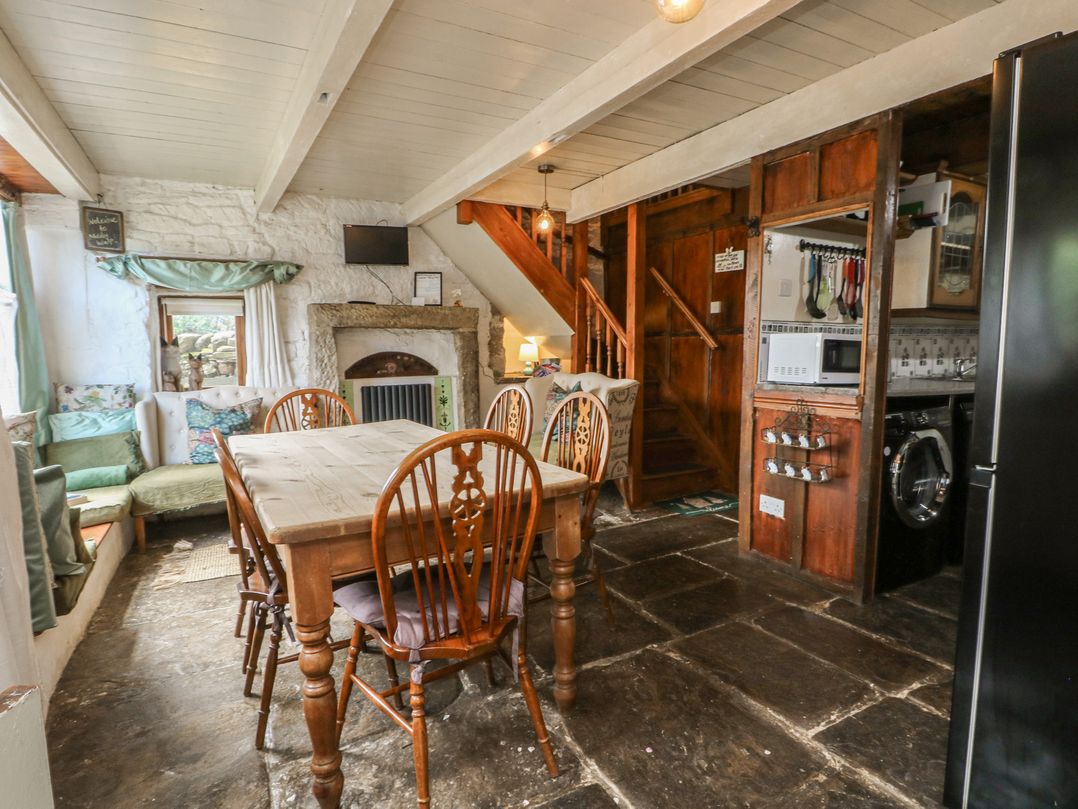 A kitchen with a dining table and chairs at Moldy Warp Barn in Haworth
