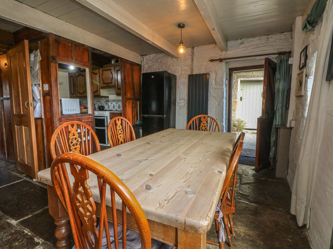 A kitchen with a dining table and chairs at Moldy Warp Barn in Haworth
