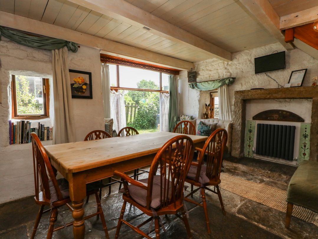 A dining room with a wooden table and chairs at Moldy Warp Barn in Haworth