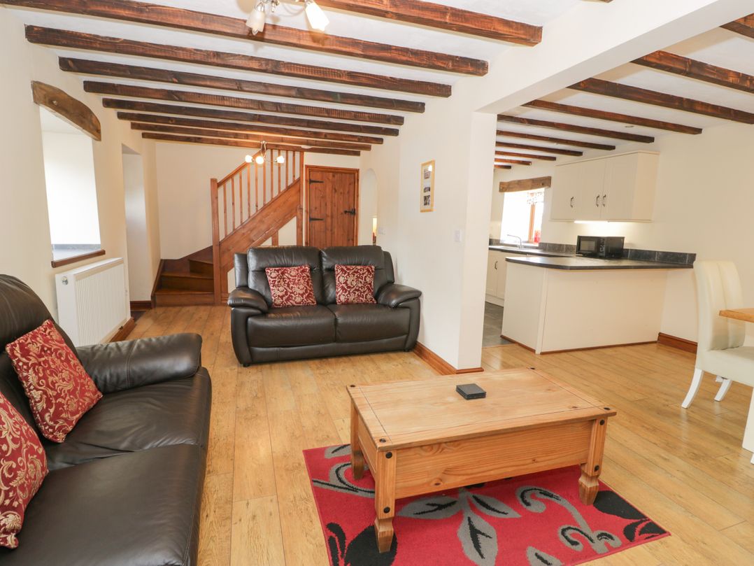 A living room with sofas and a coffee table at Stabal-y-Gwedd in Dolwen near Abergele