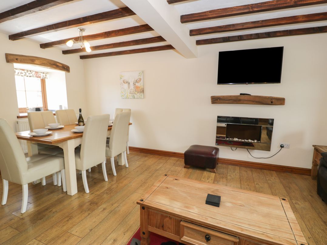 A dining room with a table and chairs at Stabal-y-Gwedd, Dolwen near Abergele