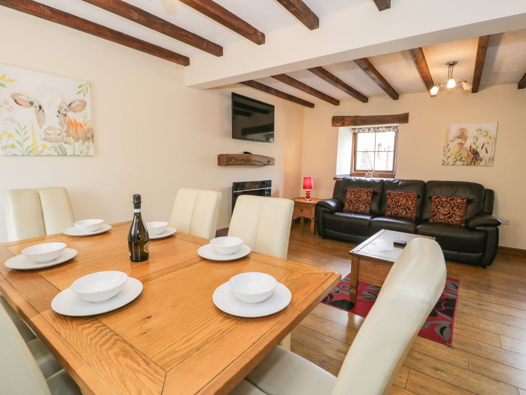 A dining area with a table and chairs at Stabal-y-Gwedd in Dolwen near Abergele