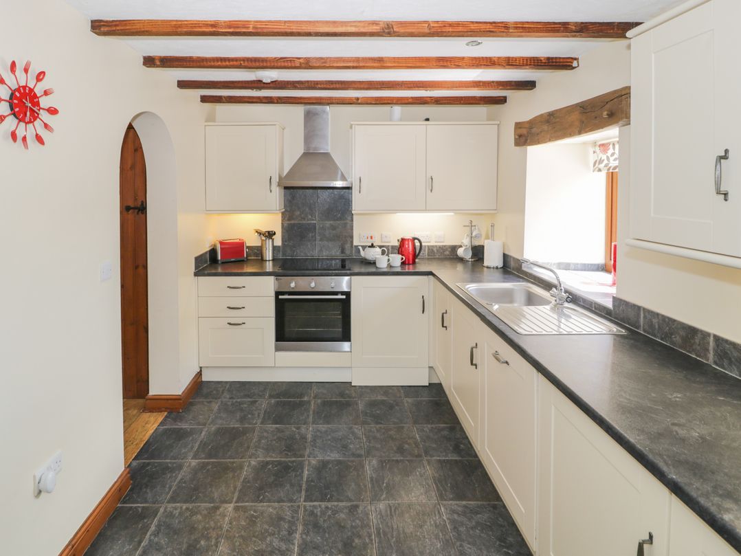 A kitchen with cabinets and appliances at Stabal-y-Gwedd in Dolwen near Abergele