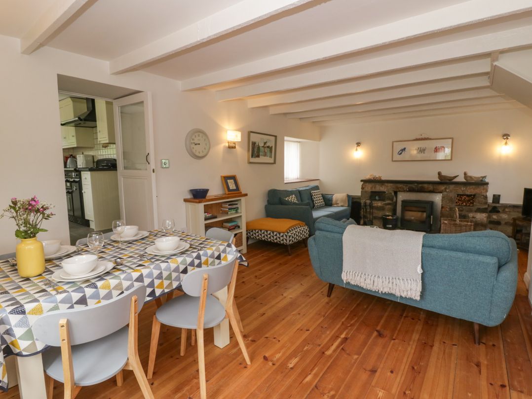 A living room with a dining area and fireplace at Little Barn Cottage Dinas Cross, Pembrokeshire