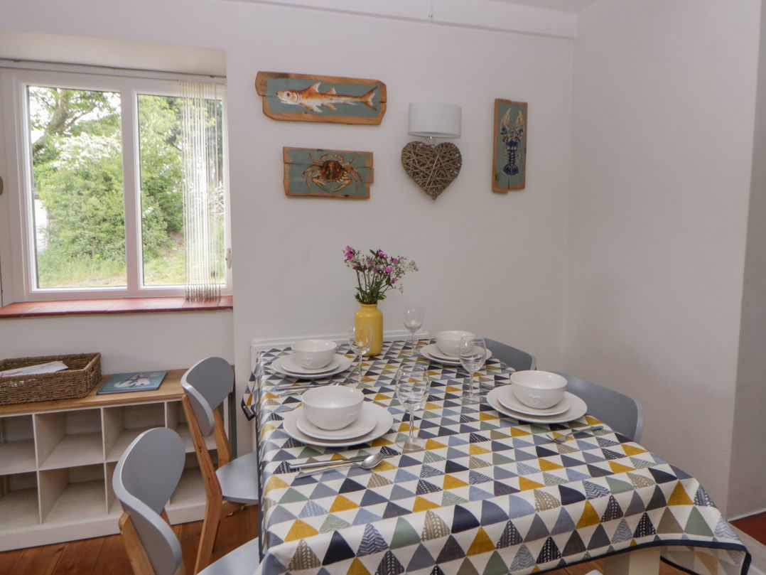 A dining room with a table set for meals at Little Barn Cottage Dinas Cross Pembrokeshire