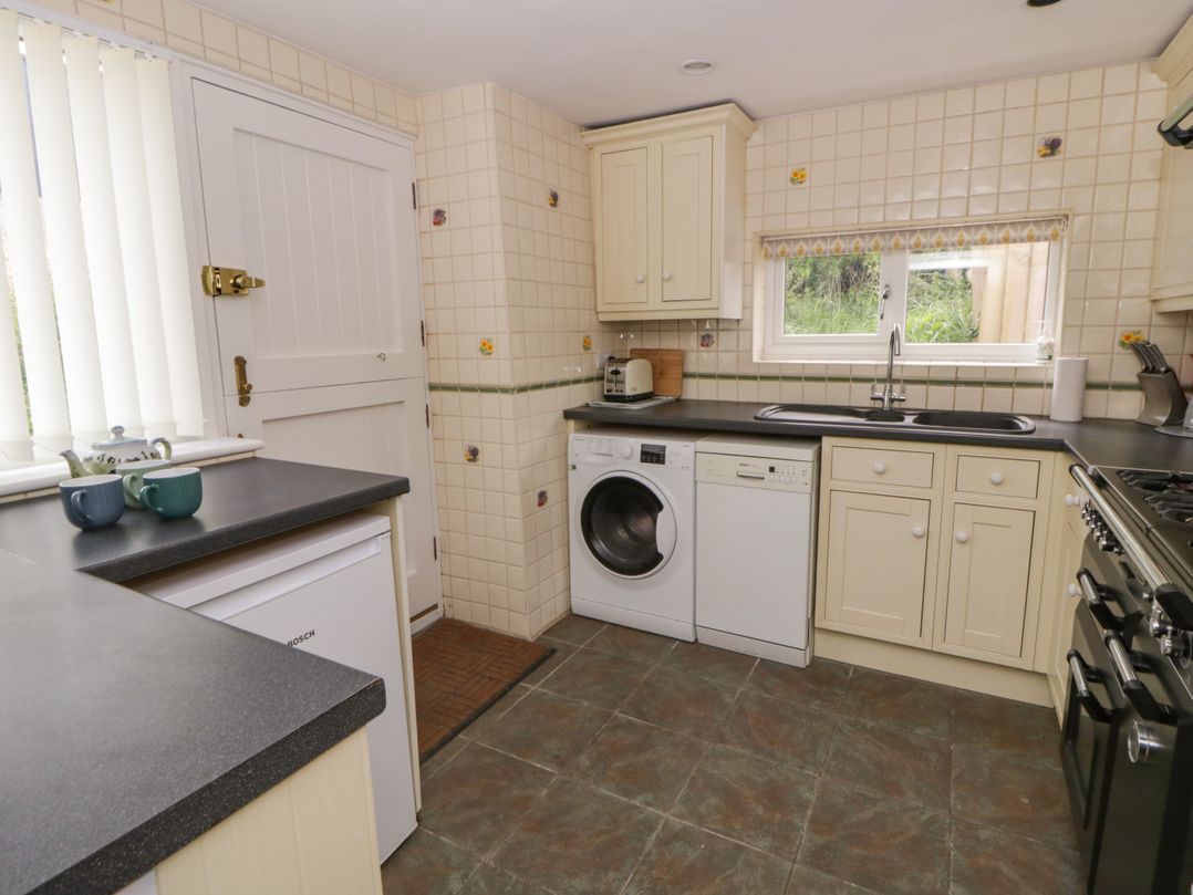 A kitchen with appliances and cabinets at Little Barn Cottage in Dinas Cross, Pembrokeshire