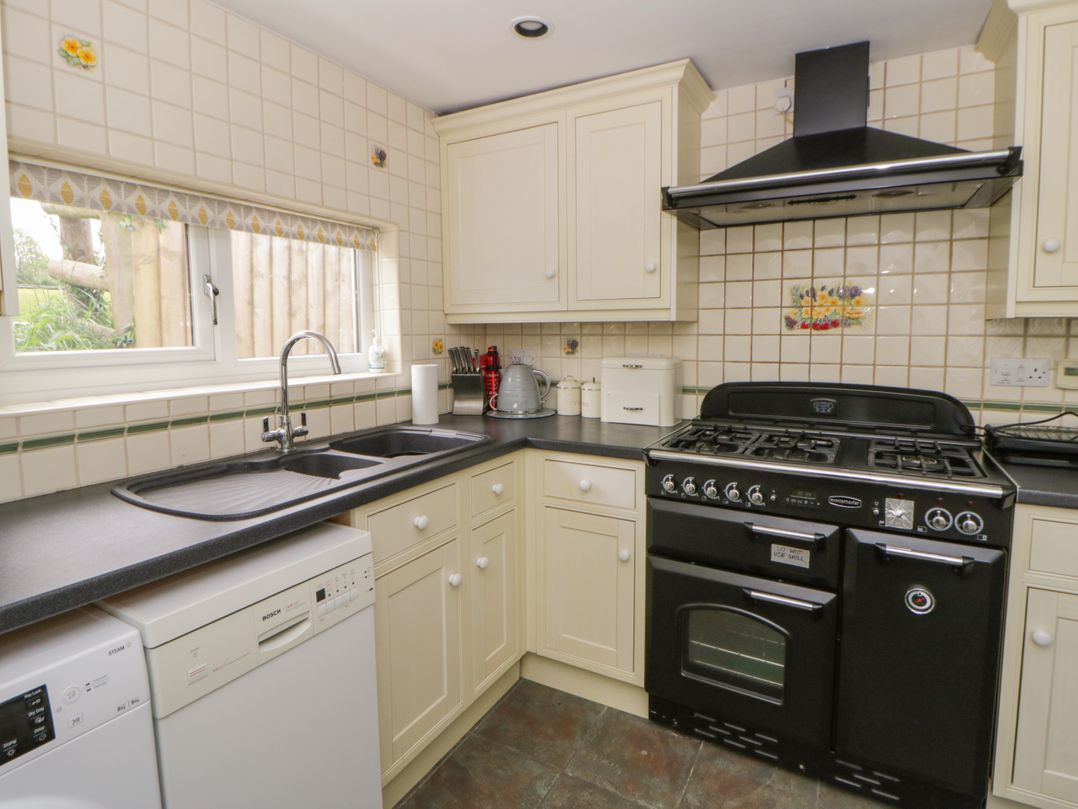 A kitchen with a stove and sink at Little Barn Cottage in Dinas Cross, Pembrokeshire