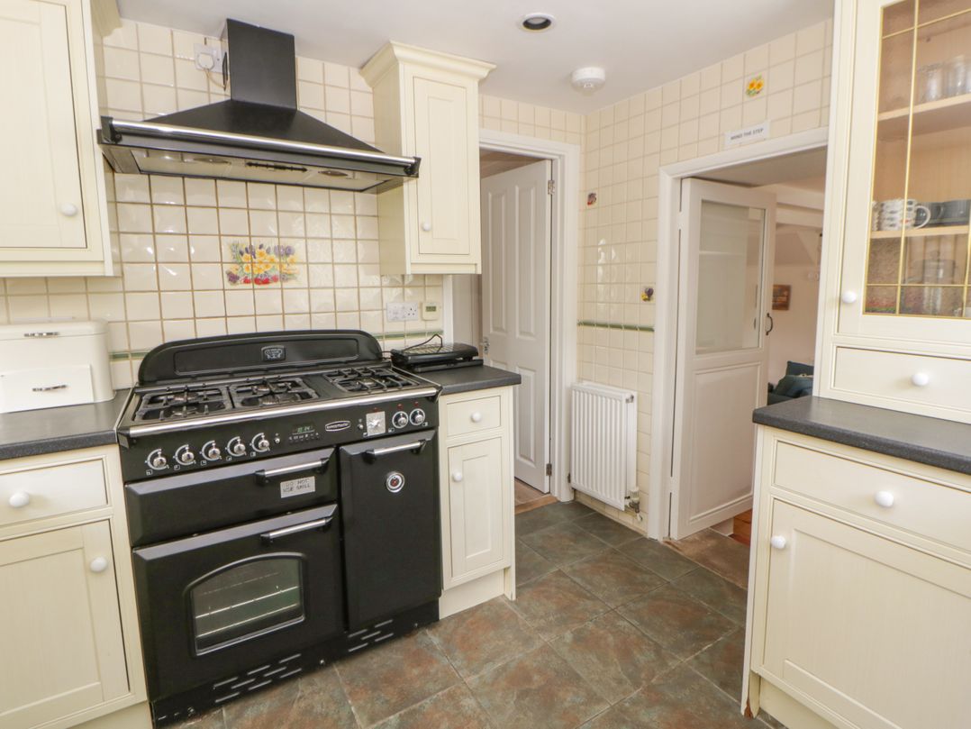 A kitchen with a cooker and cabinets at Little Barn Cottage, Dinas Cross, Pembrokeshire