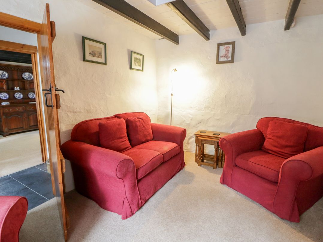 A living room with red sofas and a coffee table at Panteg, Cardigan Llangoedmor Cardigan
