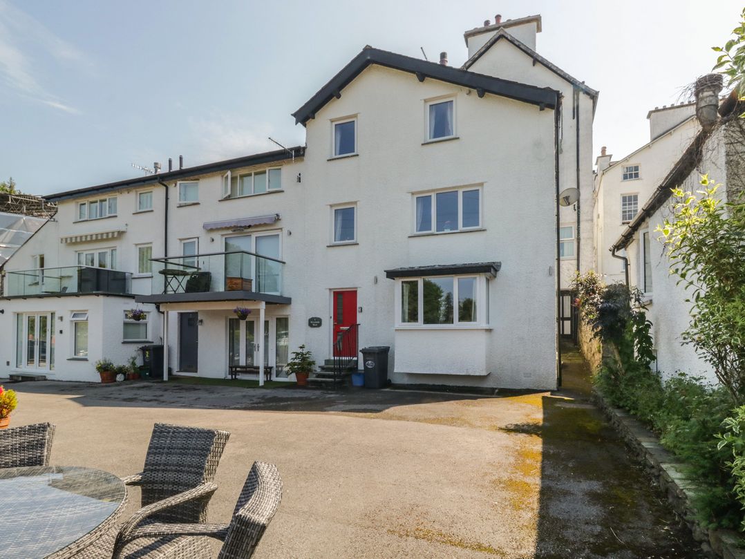 A building with a balcony and parking area at Woodside West in Bowness