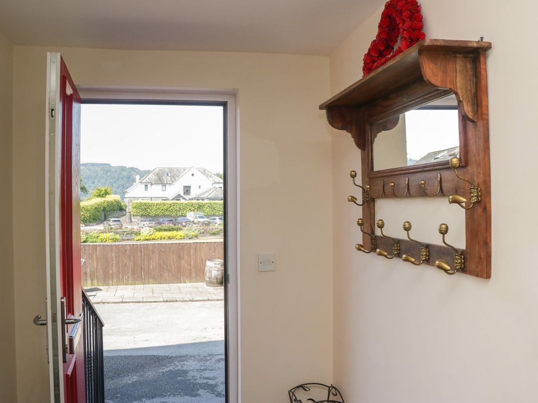 A hallway with a door and coat rack at Woodside West in Bowness