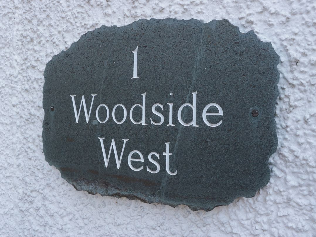 A property sign with number and name at Woodside West in Bowness