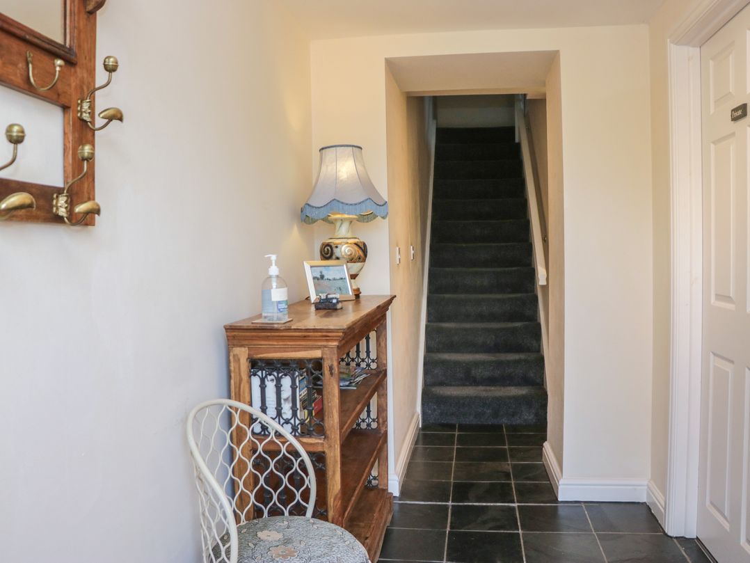 A hallway with a table and lamp at Woodside West in Bowness