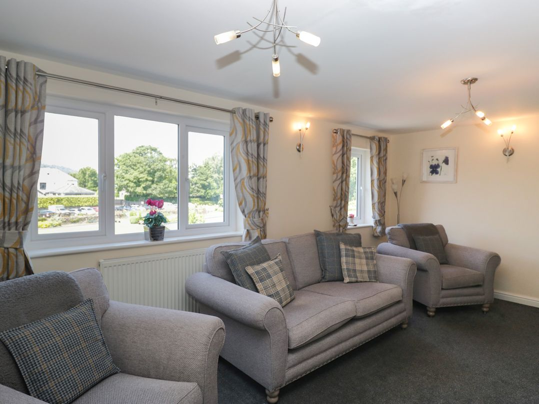 A living room with sofas and windows at Woodside West in Bowness