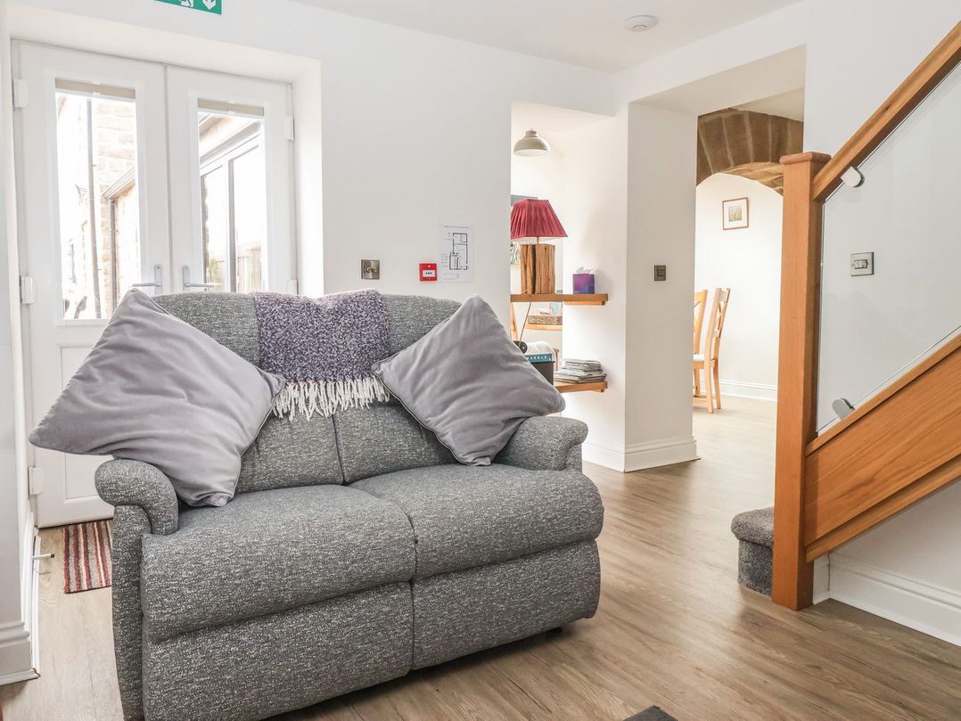 A living room with a sofa and dining area at Shepherd's Crook in Follifoot near Spofforth