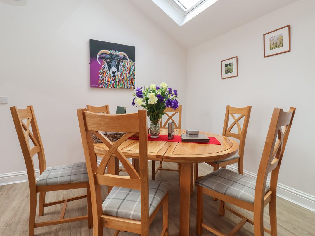 A dining room with a round table and chairs at Shepherd's Crook in Follifoot near Spofforth