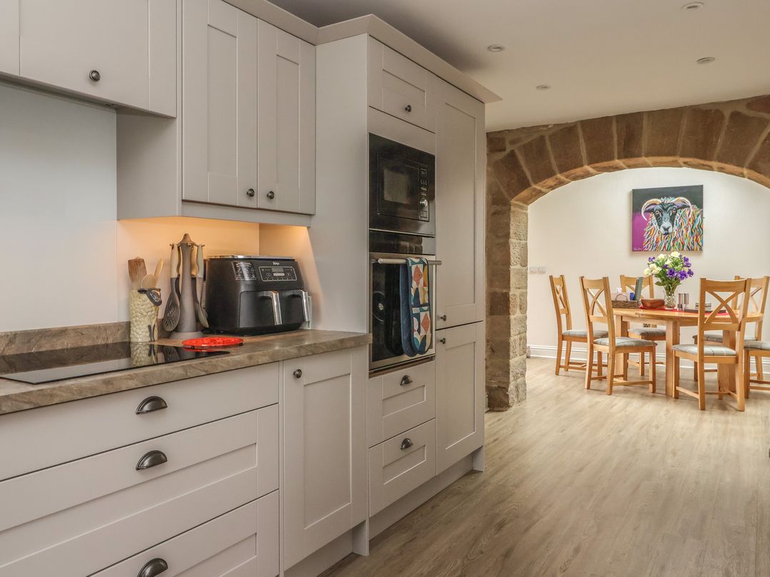 A kitchen with cabinets and a dining area at Shepherd's Crook in Follifoot near Spofforth