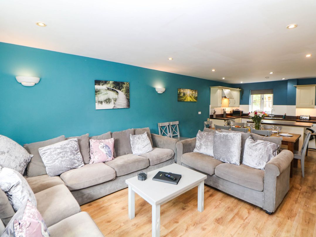A living room with a sofa and dining area at Hassop in Matlock