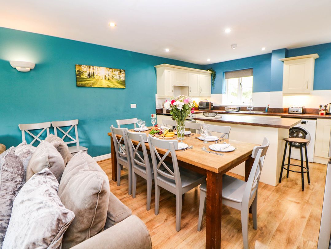 A dining room with table and kitchen units at Hassop in Matlock