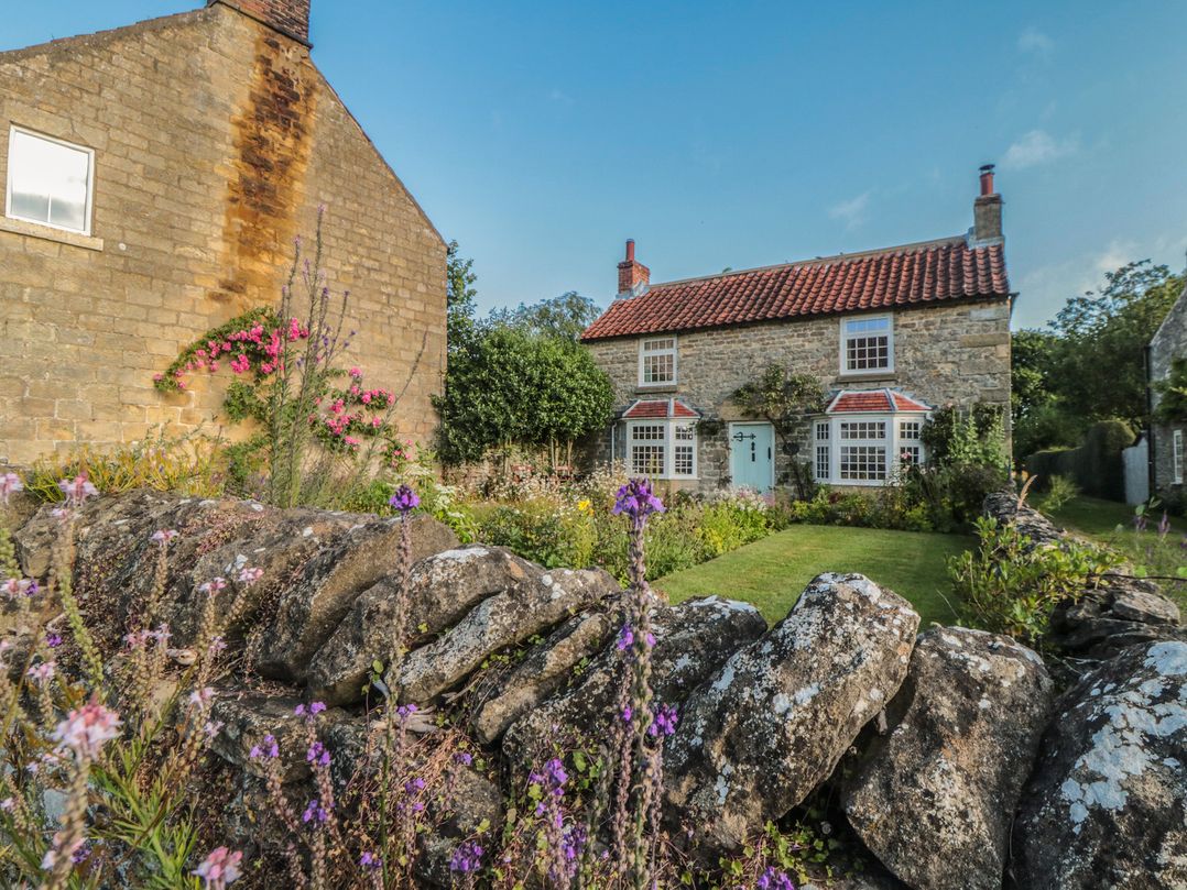 A house with a garden and stone wall at Bute Cottage Lockton near Pickering